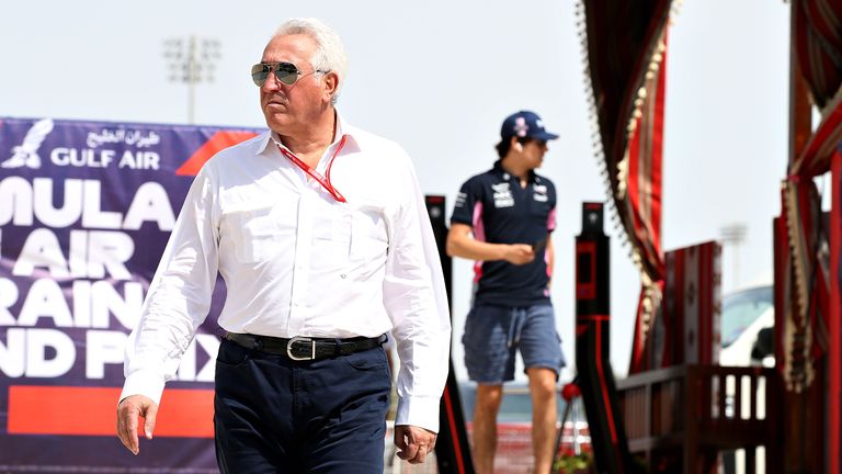 Owner of Racing Point Lawrence Stroll walks in the Paddock followed by son Lance Stroll of Canada