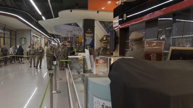 Police officers stand in the jewellery shop after the shooting on Thursday 