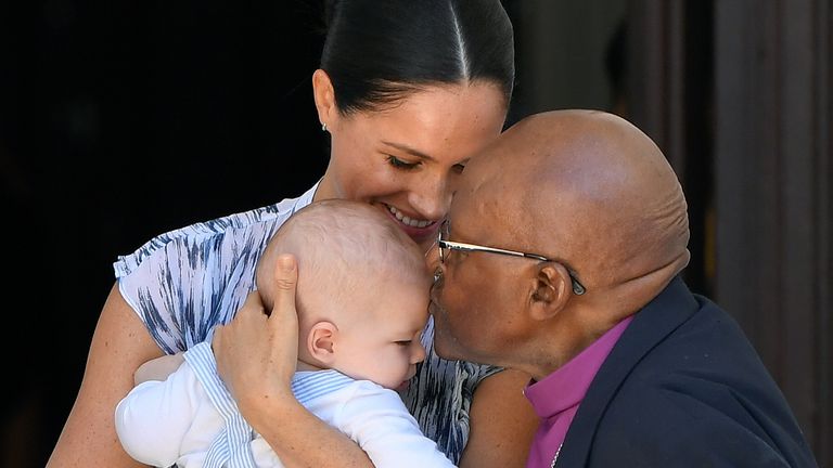 Baby Archie is kissed on the forehead by Archbishop Desmond Tutu 