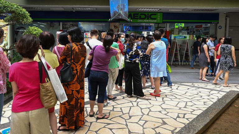 Queues for protective masks at a drugs store in Singapore