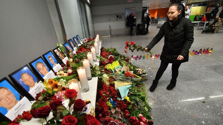 A woman places flowers at a memorial for the victims of the plane crash in Tehran