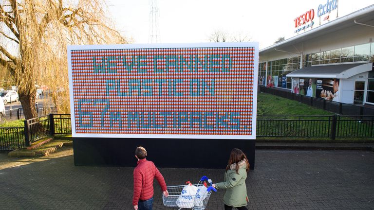 A &#39;billboard&#39; made from tins of food is unveiled outside Tesco Extra in Watford 