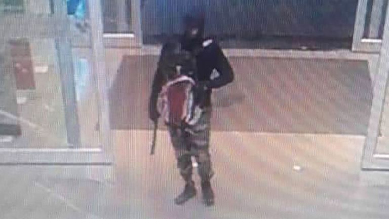 Suspect wearing balaclava, camouflage pants and carrying a handgun with suppressor attached, as they arrive to rob a gold shop inside a department store in Lopburi province, Thailand