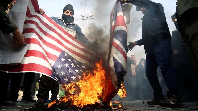 Protesters burn the US and British flags during a protest against killing of Iranian Major General Qassem Soleimani