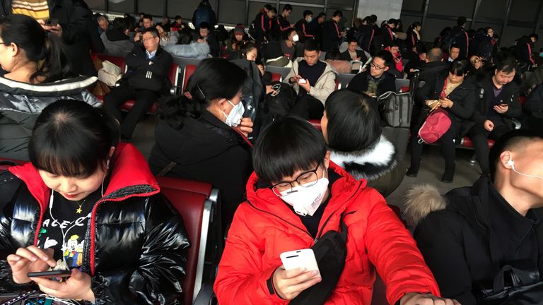 Passengers wearing face masks wait for their train to Wuhan at Beijing West railway ahead of Chinese New Year