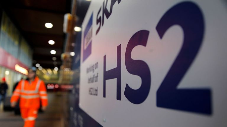 A worker walks past a sign outside a construction site for a section of Britain's HS2 high-speed railway project, at London Euston train station in London on January 20, 2020. - Britain's government on Monday said it would shortly decide on whether to proceed with its HS2 high-speed two railway project, whose cost is reportedly set to soar to more than £100 billion. HS2, which will quicken rail journeys between London in southeast England and cities to the north of the capital, has been dogged by controversy owing to projected spiralling costs and damage to wildlife. (Photo by Tolga AKMEN / AFP) (Photo by TOLGA AKMEN/AFP via Getty Images)