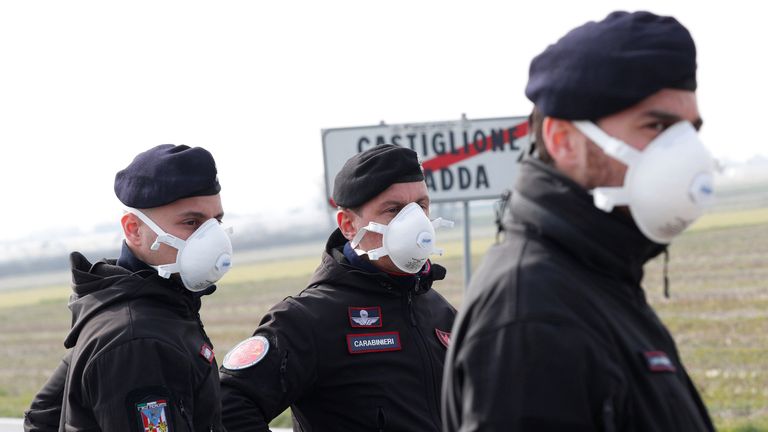 Carabinieri officers stand guard outside the town of Castiglione D'Adda, which has been closed by the Italian government due to a coronavirus outbreak, Italy, February 23, 2020. REUTERS/Guglielmo Mangiapane