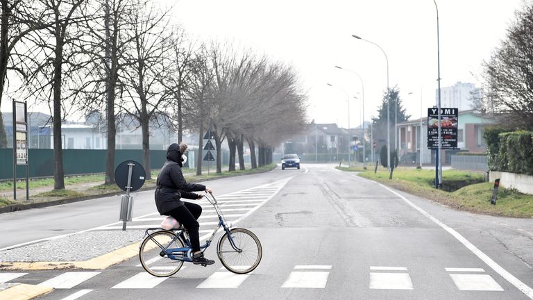 A person wearing a face mask rides a bicycle in the town of Codogno, which has been closed by the Italian government due to a coronavirus outbreak in northern Italy, February 23, 2020. REUTERS/Flavio Lo Scalzo