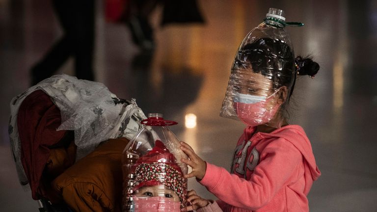 BEIJING, CHINA - JANUARY 30: Chinese children wear plastic bottles as makeshift homemade protection and protective masks while waiting to check in to a flight at Beijing Capital Airport on January 30, 2020 in Beijing, China. The number of cases of a deadly new coronavirus rose to over 7000 in mainland China Thursday as the country continued to lock down the city of Wuhan in an effort to contain the spread of the pneumonia-like disease which medicals experts have confirmed can be passed from human to human. In an unprecedented move, Chinese authorities put travel restrictions on the city which is the epicentre of the virus and neighbouring municipalities affecting tens of millions of people. The number of those who have died from the virus in China climbed to over 170 on Thursday, mostly in Hubei province, and cases have been reported in other countries including the United States, Canada, Australia, Japan, South Korea, and France. The World Health Organization  has warned all governments to be on alert, and its emergency committee is to meet later on Thursday to decide whether to declare a global health emergency. (Photo by Kevin Frayer/Getty Images)