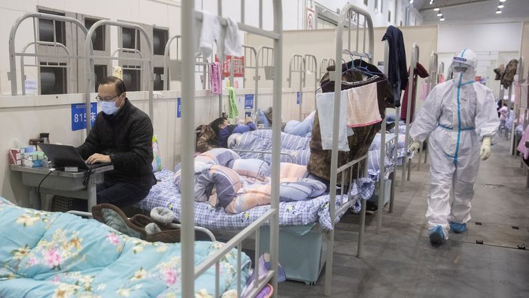 TOPSHOT - This photo taken on February 17, 2020 shows a man (L) who has displayed mild symptoms of the COVID-19 coronavirus using a laptop at an exhibition centre converted into a hospital in Wuhan in China&#39;s central Hubei province. - The death toll from the COVID-19 coronavirus epidemic jumped to 1,868 in China on February 18 after 98 more people died, according to the National Health Commission. (Photo by STR / AFP) / China OUT (Photo by STR/AFP via Getty Images)