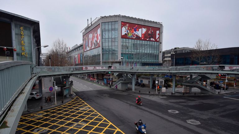 Motorcyclists ride in an almost empty street in Wuhan, in China's central Hubei province on February 26, 2020. - China on February 26 reported 52 new coronavirus deaths, the lowest figure in more than three weeks, bringing the death toll to 2,715. All the new deaths were in the outbreak epicentre Hubei province, which accounted for 401 of the 406 new infections reported on February 26, the National Health Commission said. (Photo by STR / AFP) / China OUT (Photo by STR/AFP via Getty Images)