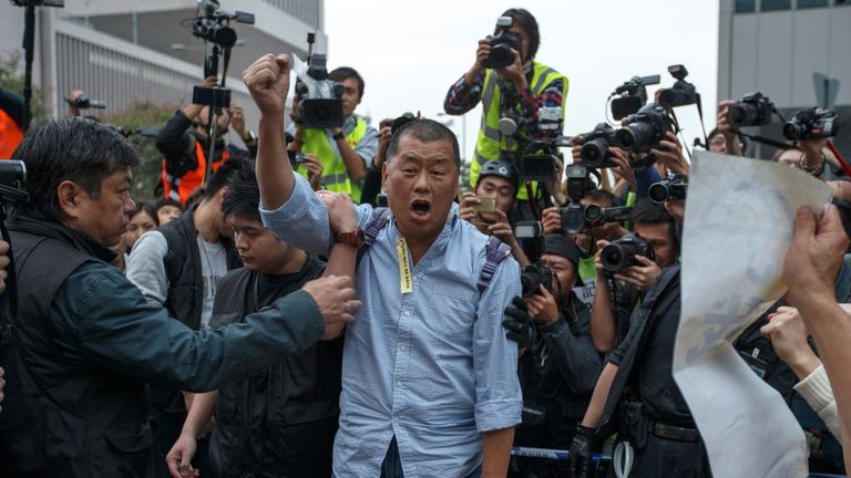 Tycoon and Apple Daily Newspaper owner Jimmy Lai shouts slogan before he is taken away by police officer at an area previously blocked by pro-democracy supporters, outside the government headquarters in Hong Kong, December 11, 2014. Hong Kong authorities started on Thursday clearing the main pro-democracy protest site that has choked roads into the city's most economically and politically important district for more than two months as part of a campaign to demand free elections. REUTERS/Athit Perawongmetha (CHINA - Tags: POLITICS CIVIL UNREST BUSINESS)