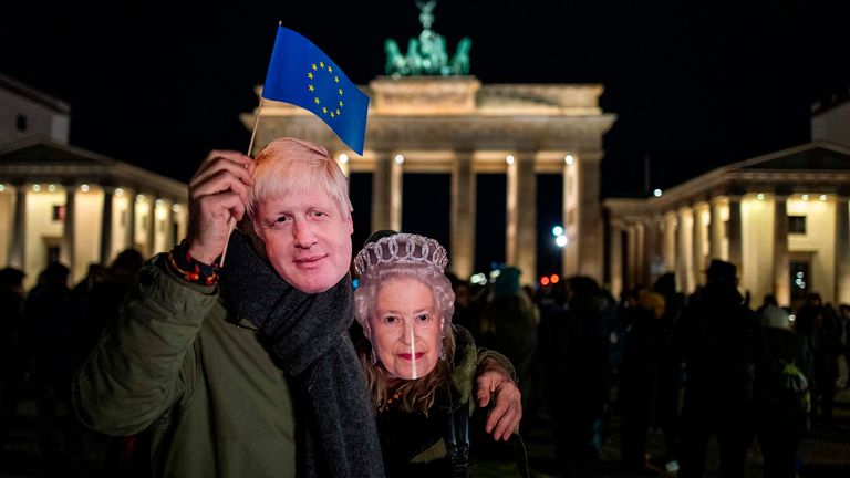 A couple in Berlin wearing Boris Johnson and Queen masks to mark Britain&#39;s EU departure