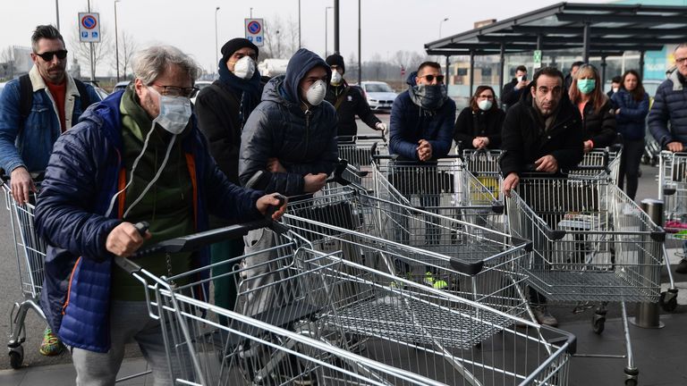 Residents wait to be given access to shop in a supermarket in small groups of forty people on February 23, 2020 in the small Italian town of Casalpusterlengo