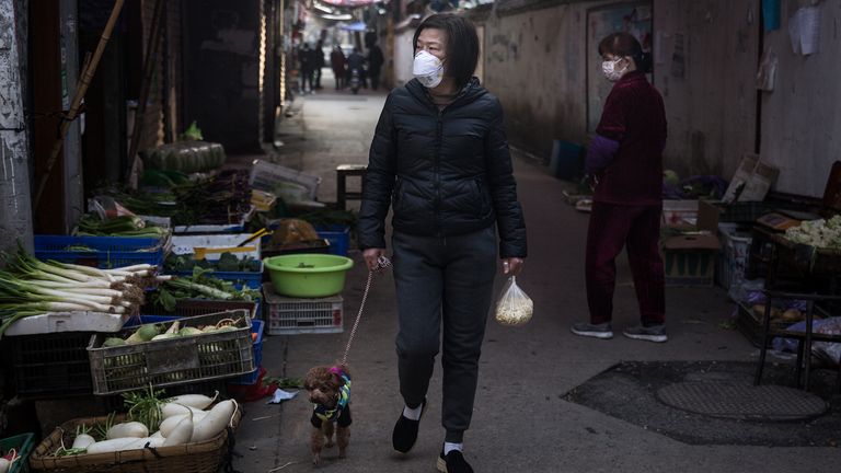 WUHAN, CHINA - JANUARY 31: (CHINA OUT) A woman wears a protective mask as she walks her dog and buys vegetables in an alley on January 31, 2020 in Wuhan, China. World Health Organization (WHO) Director-General Tedros Adhanom Ghebreyesus said on January 30 that the novel coronavirus outbreak has become a Public Health Emergency of International Concern (PHEIC). (Photo by Stringer/Getty Images)
