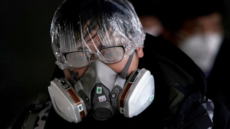 A passenger wearing a mask walks outside the Shanghai railway station in Shanghai, China