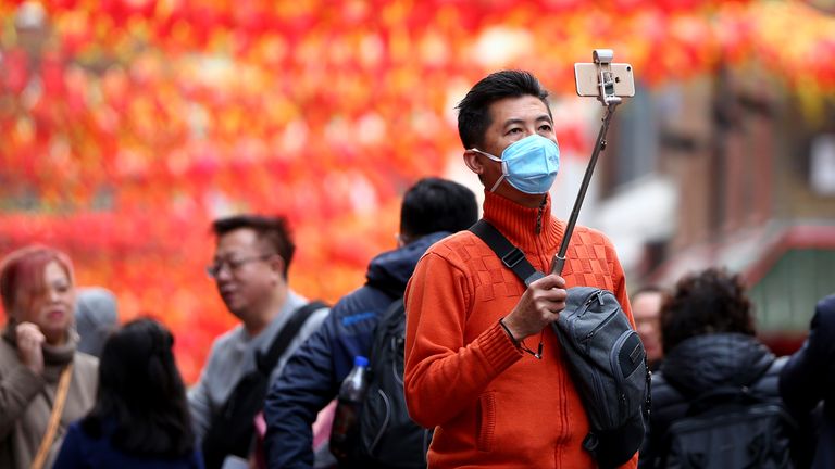 A man wears a face mask in Chinatown, London