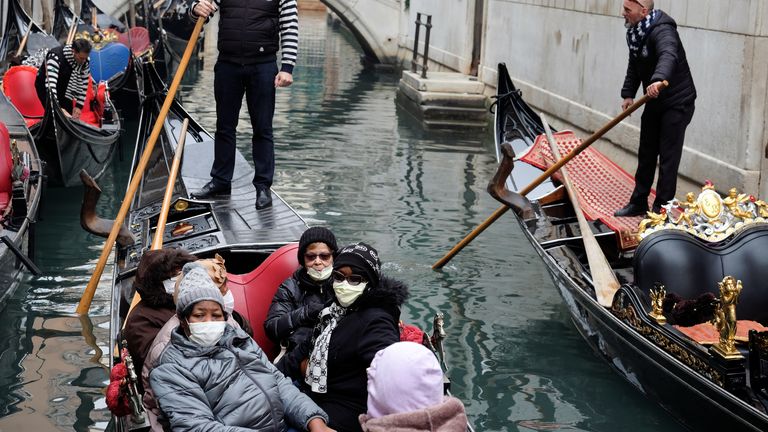 Tourists wear protective face masks in a gondola, because of an outbreak of coronavirus, in Venice, Italy February 23, 2020