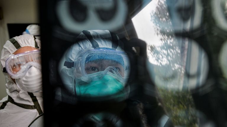 Medical workers in protective suits check a CT (computed tomography) scan in Wuhan