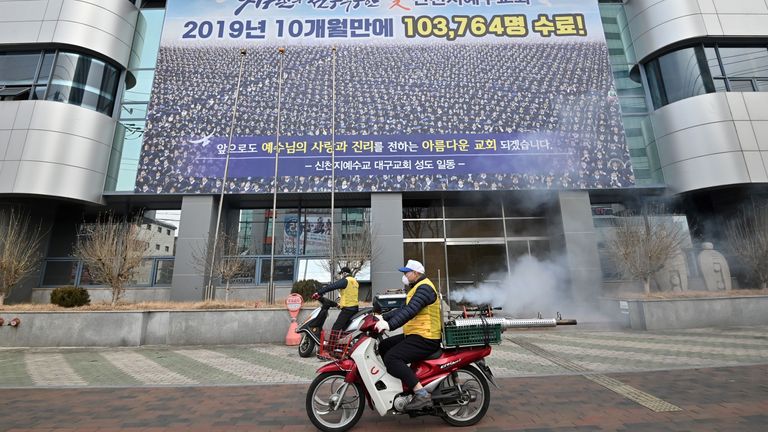 Disinfectant is sprayed in front of the Shincheonji Church of Jesus in Daegu