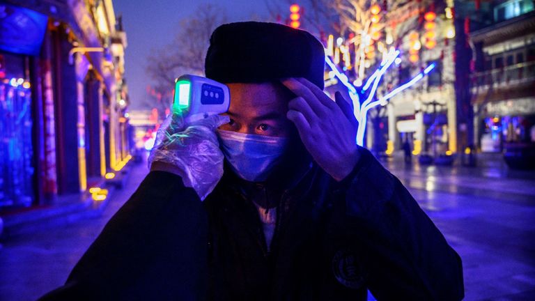 A Chinese worker is tested for the coronavirus on an empty street in Beijing