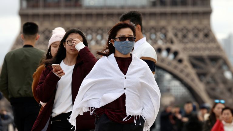 Tourists at the Eiffel Tower in Paris, as France confirms its first coronavirus death. File picture