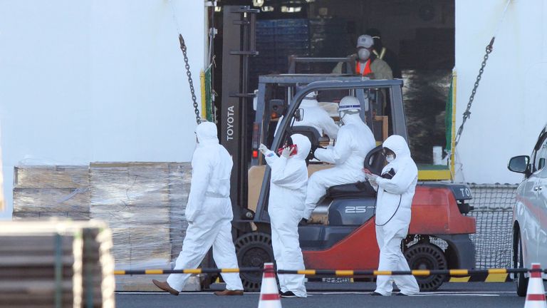 Personnel dressed in white protective suits load relief supplies for passengers onboard the Diamond Princess cruise ship at the Daikoku Pier Cruise Terminal in Yokohama port on February 6, 2020. - Ten more people on a cruise ship off Japan&#39;s coast have tested positive for the new coronavirus, the health minister said February 6, raising the number of infections detected on the boat to 20. (Photo by STR / JIJI PRESS / AFP) / Japan OUT (Photo by STR/JIJI PRESS/AFP via Getty Images)
