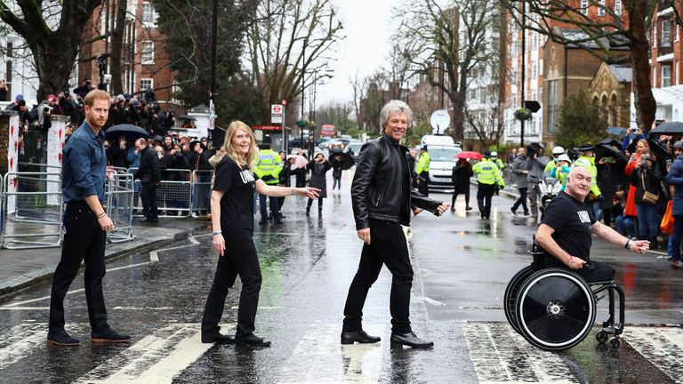 The Duke of Sussex, Jon Bon Jovi and members of the Invictus Games Choir walk on the famous zebra crossing outside the Abbey Road Studios in London