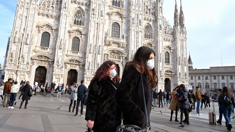 Women wearing a respiratory mask walks across Piazza del Duomo in central Milan on February 23, 2020. - Tens of thousands of Italians prepared for a weeks-long quarantine in the country&#39;s north on February 23 as nerves began to fray among the locals faced with new lockdown measures