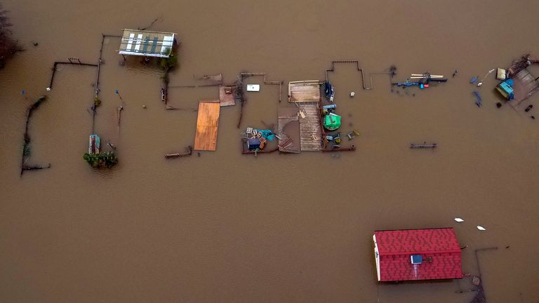 Swans can be seen swimming past a flooded house in Worcestershire