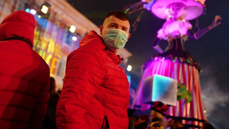 Revellers wear masks to protect themselves from the COVID-19 illness as they attend the Nice carnival on the french riviera city of Nice, on February 25, 2020