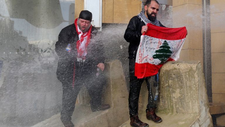 Demonstrators in Beirut are sprayed with a water cannon while trying to prevent MPs reaching the parliament