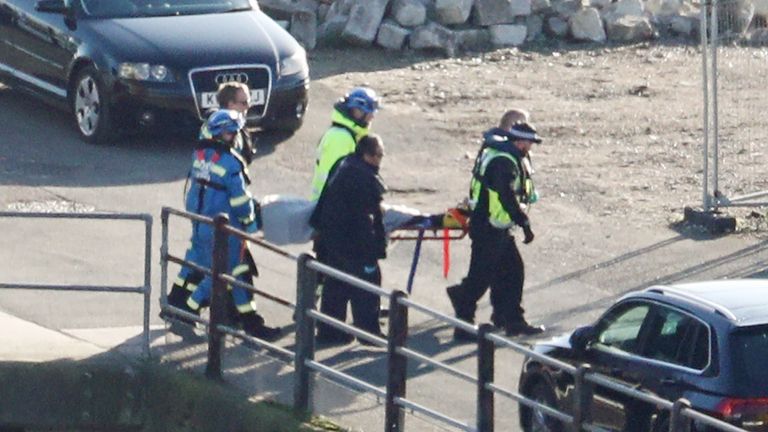 A suspected migrant is brought ashore on a stretcher in Dover