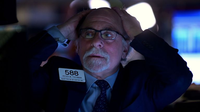 A trader is seen on the floor of the New York Stock Exchange as values plunged on Monday amid fears of a wider global hit from COVID-19