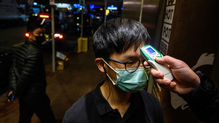 A restaurant worker has his temperature taken in Hong Kong