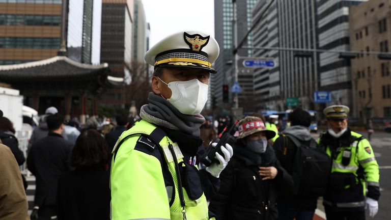 A South Korean policeman wear mask to prevent the coronavirus (COVID-19) walks along the street on February 22, 2020 in Seoul, South Korea. South Korea reported 229 new cases of the coronavirus (COVID-19) bringing the total number of infections in the nation to 433