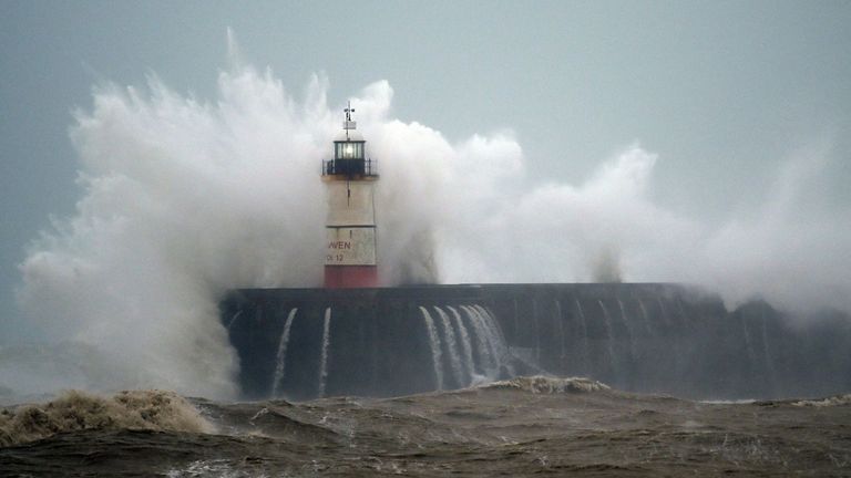 Waves crash over Newhaven Lighthouse on the south coast of England as Storm Ciara sweeps in