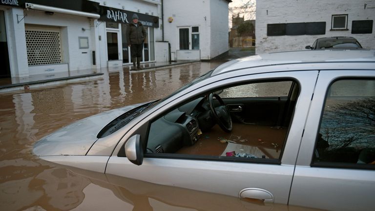 Flood water surrounds abandoned cars left in a flooded street in Tenbury Wells, after the River Teme burst its banks in western England, on February 16, 2020, after Storm Dennis caused flooding across large swathes of Britain