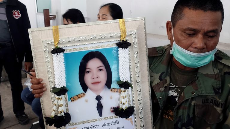 A relative holds a picture of Patchara Chanpeng, one of the gunman's victims