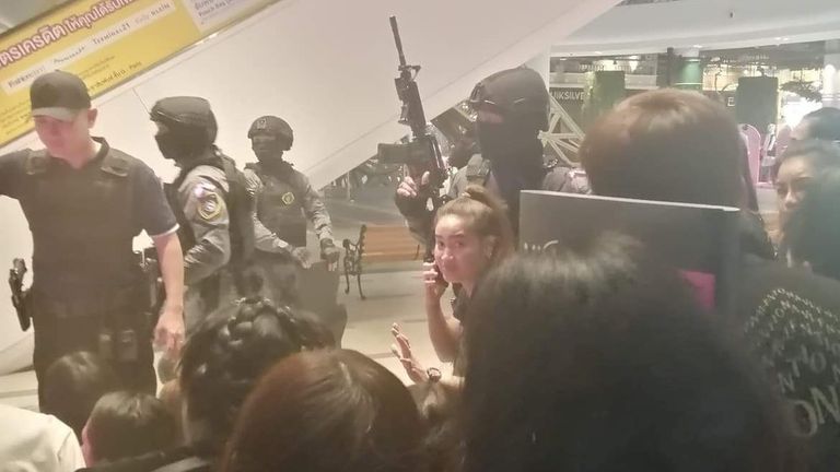 People are evacuated from the Terminal 21 shopping mall by members of security forces 