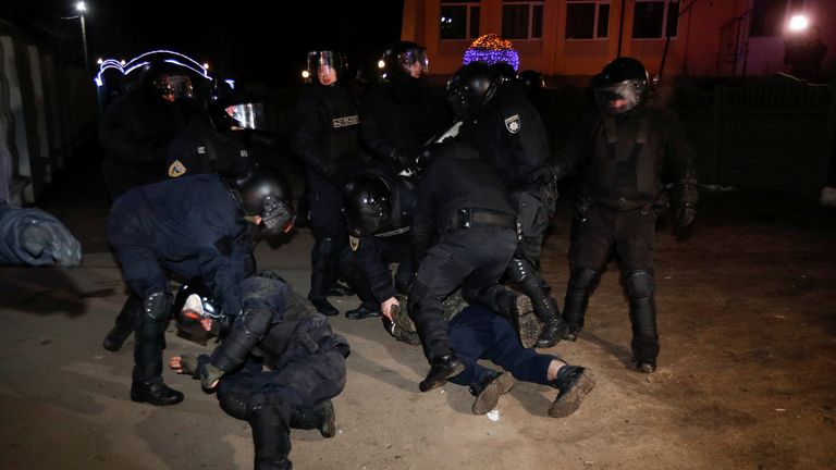 Police officers are seen detaining a man during the violence 