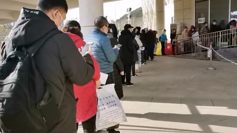 Those showing signs of coronavirus queue outside a makeshift hospital in Wuhan