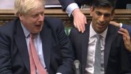 Chancellor Rishi Sunak (right) sits down after delivering his Budget in the House of Commons, London