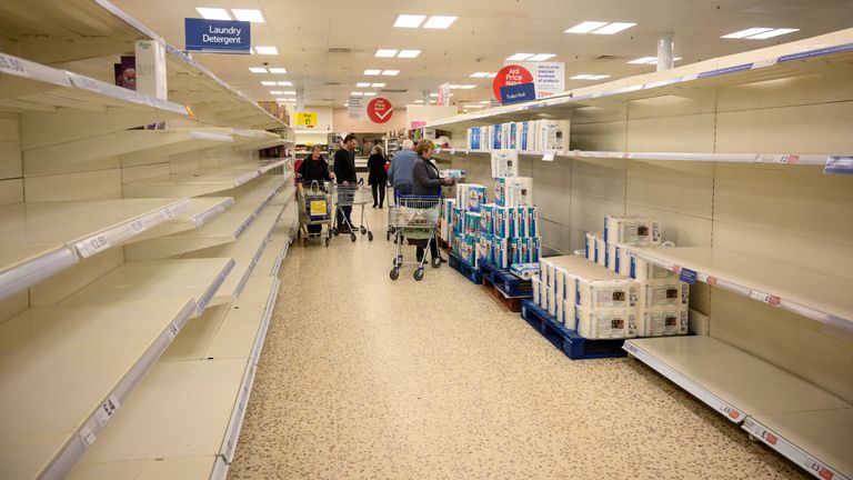 Shoppers peruse near-empty toilet roll shelves at a  supermarket in the centre of York, northern England, on March 19, 2020. - Britain's supermarkets on Wednesday stepped up efforts to safeguard supplies, especially for vulnerable and elderly customers, as the sector battles stockpiling caused by coronavirus panic. (Photo by OLI SCARFF / AFP) (Photo by OLI SCARFF/AFP via Getty Images)