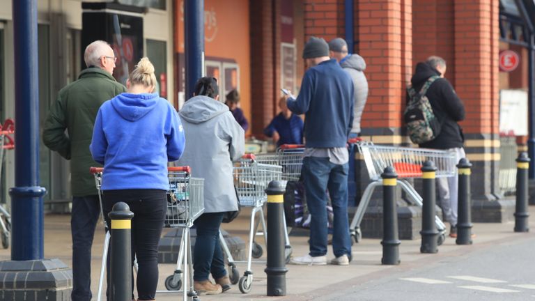 People queue at a Sainsbury's supermarket at Colton, on the outskirts of Leeds, the day after Prime Minister Boris Johnson put the UK in lockdown to help curb the spread of the coronavirus.