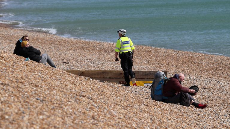 An officer tells people to leave Brighton beach as the public has been urged to stay at home