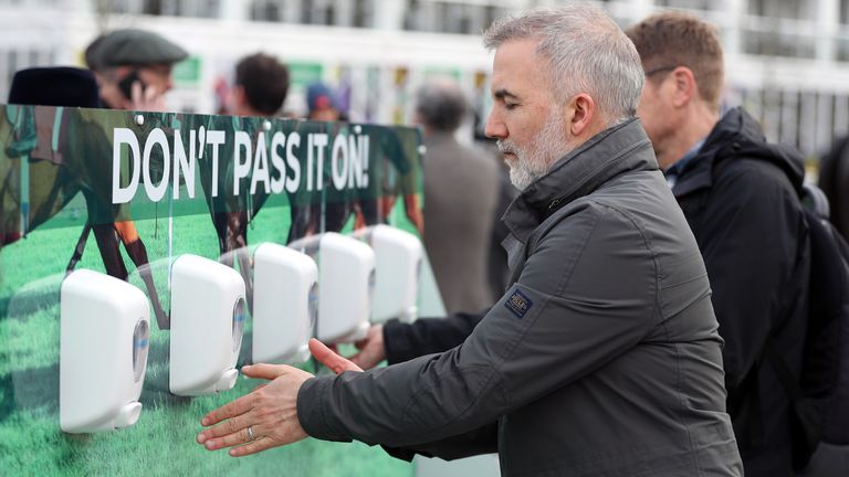 Racegoers use hand sanitiser to keep their hands clean following an outbreak of the Coronavirus on day one of the Cheltenham Festival at Cheltenham Racecourse, Cheltenham.