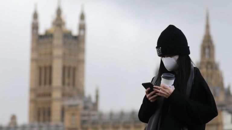 A pedestrian wearing a face mask walks along Westminster Bridge in front of the Houses of Parliament in London on March 12, 2020. - The British government was expected Thursday to implement the second phase of its plan to deal with the coronavirus outbreak but rejected calls for parliament to be suspended after an MP tested positive. (Photo by ISABEL INFANTES / AFP) (Photo by ISABEL INFANTES/AFP via Getty Images)
