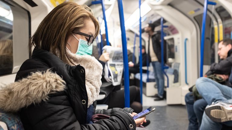 A woman wears a face mask on the London Underground