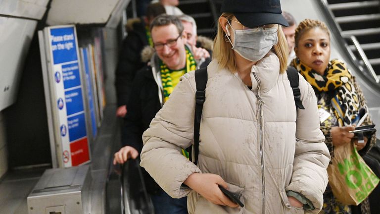 A woman wears a mask as she uses the Underground transport system in London